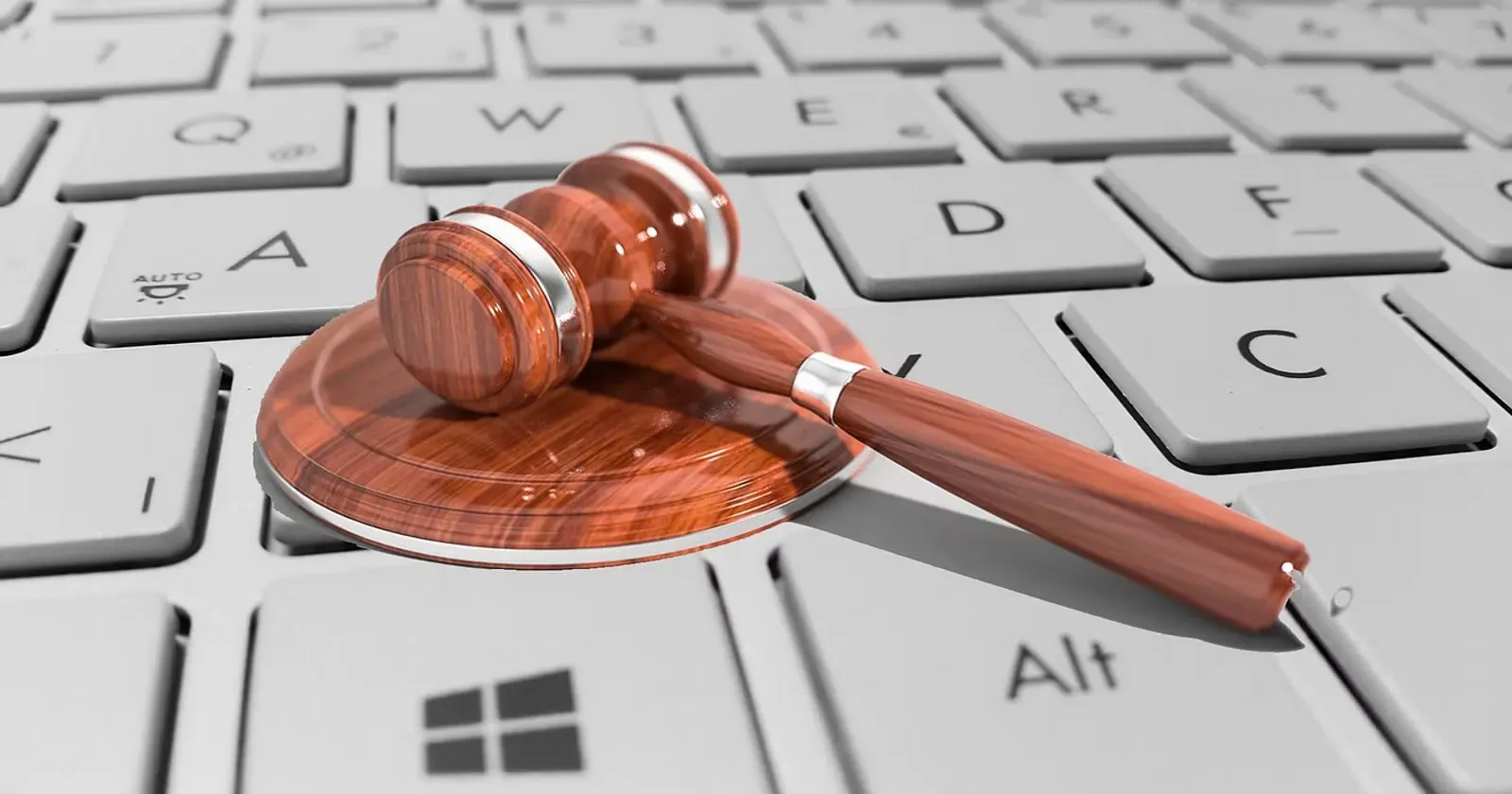 A judge's gavel resting on a computer keyboard